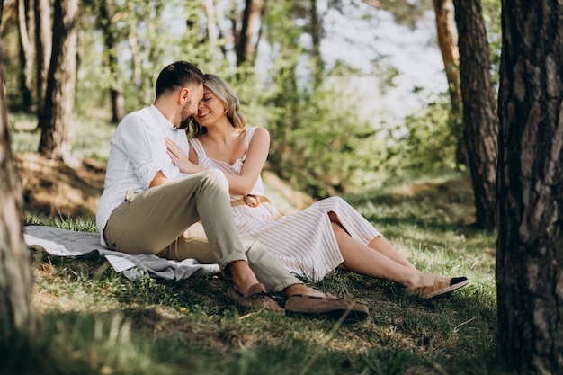 Jovem casal fazendo piquenique na floresta