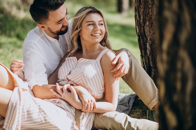 Jovem casal fazendo piquenique na floresta