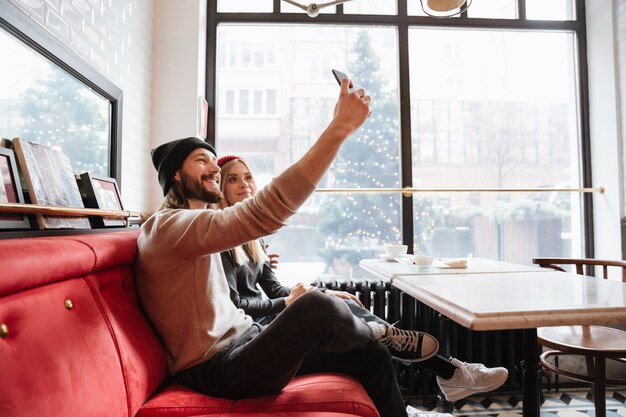 Jovem casal fazendo selfie no café