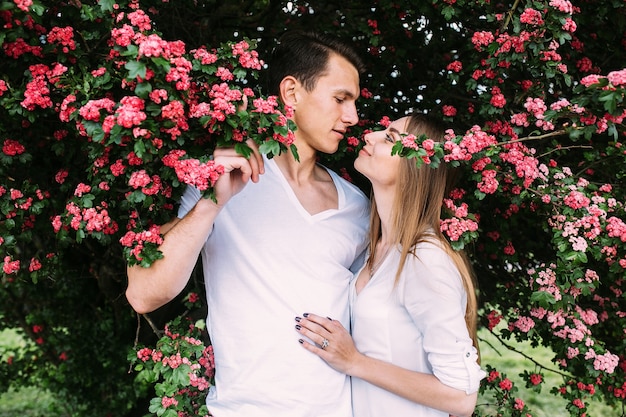 Jovem casal feliz apaixonado ao ar livre. amar o homem e a mulher em uma caminhada em um parque florido de primavera