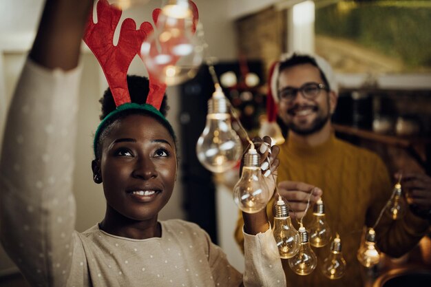 Jovem casal feliz decorando sua casa na véspera de Natal