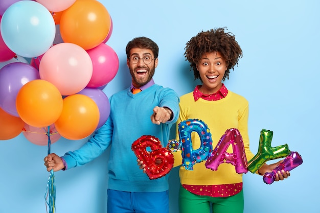 Jovem casal feliz em uma festa posando com balões