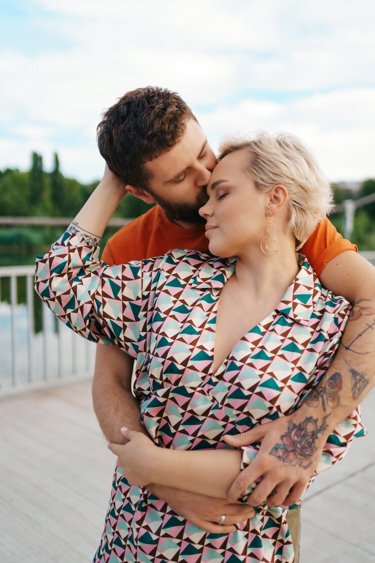Foto grátis jovem casal feliz se abraçando e rindo ao ar livre.