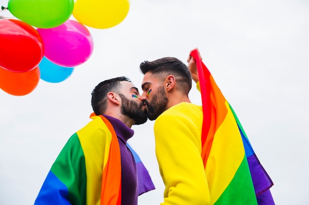 Foto grátis jovem casal gay beijando na parada