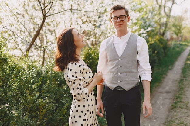 Jovem casal homem e mulher em um jardim florescendo