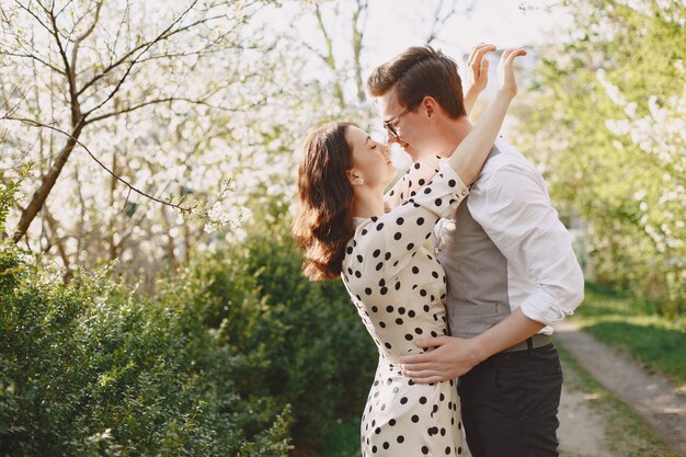 Jovem casal homem e mulher em um jardim florescendo