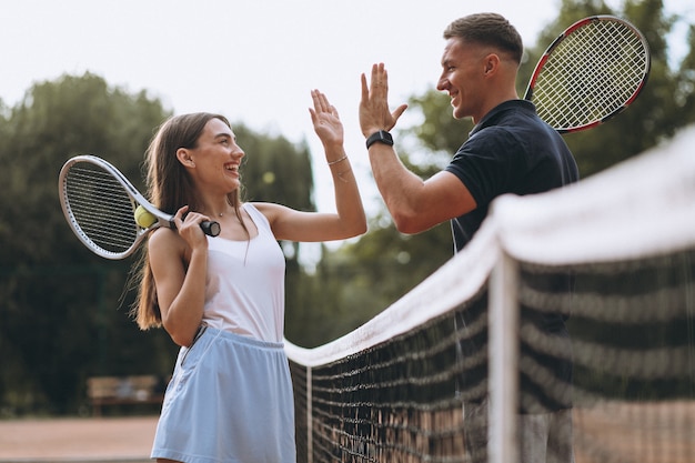 Foto grátis jovem casal jogando tênis na quadra