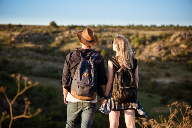 Jovem casal lindo descansando, apreciando a vista no canyon