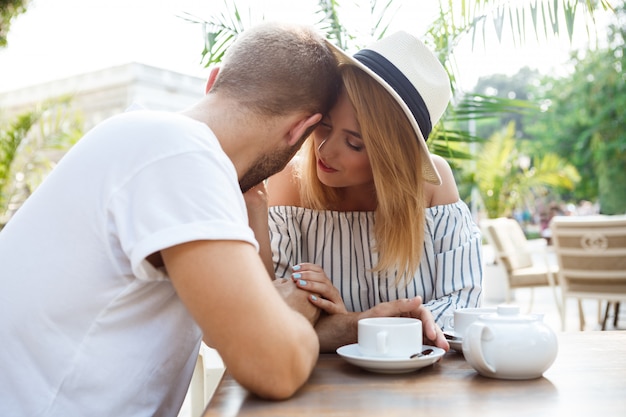 Jovem casal lindo falando, sorrindo, descansando no café.