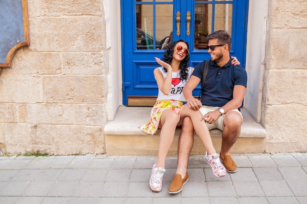 Jovem casal lindo hippie apaixonado, sentado na rua da cidade velha