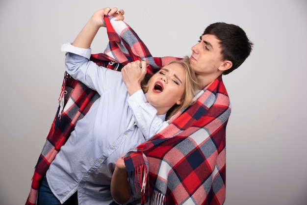 Jovem casal lindo parado em um cobertor xadrez e posando