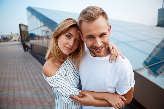 Jovem casal lindo sorrindo, abraçando, andando pela cidade.