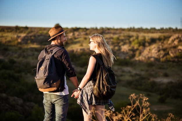 Jovem casal lindo sorrindo, olhando um ao outro no canyon