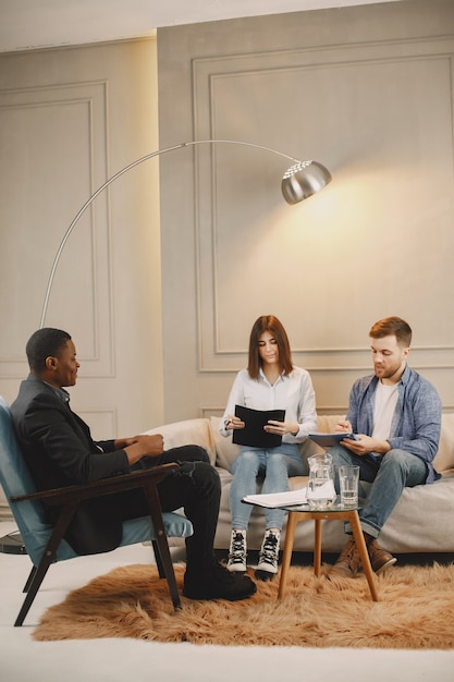 Jovem casal no gabinete do psicólogo. Eles estão fazendo teste ou enchendo o cobertor para terapia.