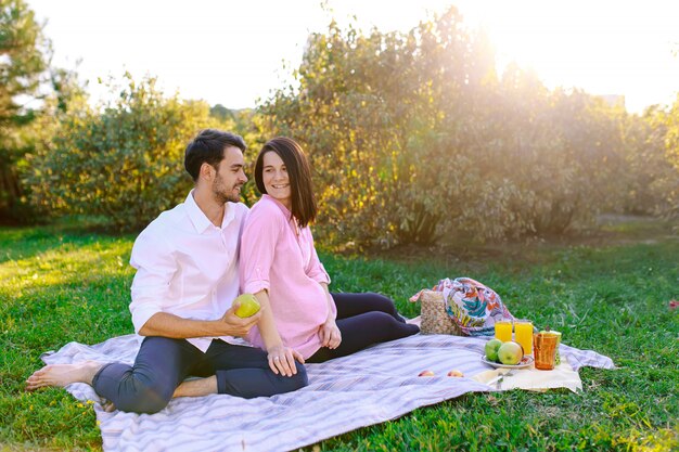 Jovem casal no parque ao ar livre, fazendo um piquenique