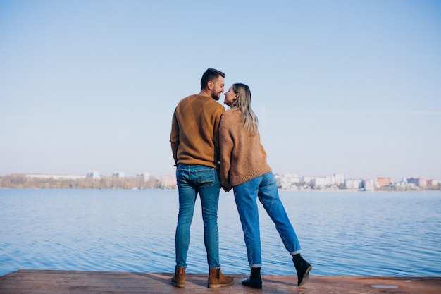 Foto grátis jovem casal no parque em pé junto ao rio