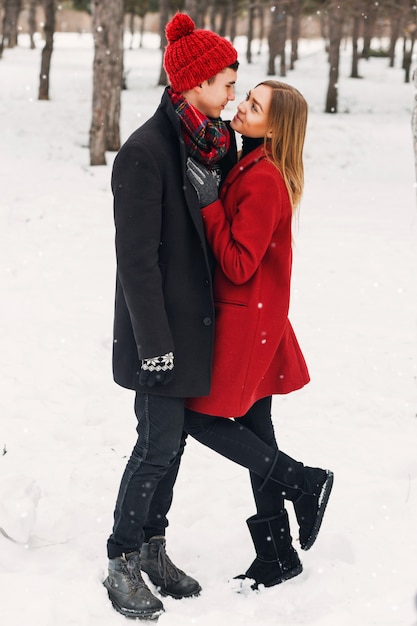 Jovem casal olhando um ao outro em um campo nevado