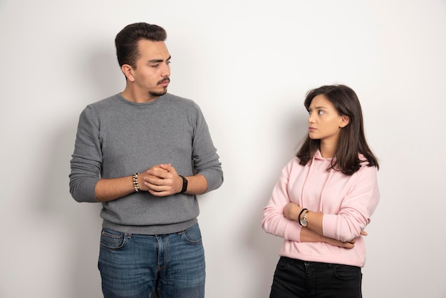 Jovem casal olhando um para o outro em branco.