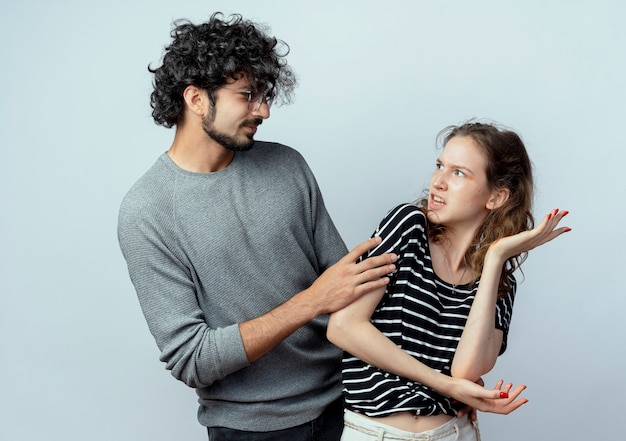 Jovem casal pedindo perdão mulher descontente após briga em pé com os braços levantados sobre fundo branco