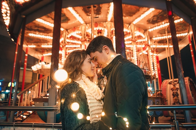 Foto grátis jovem casal se beijando e se abraçando ao ar livre na rua à noite na época do natal