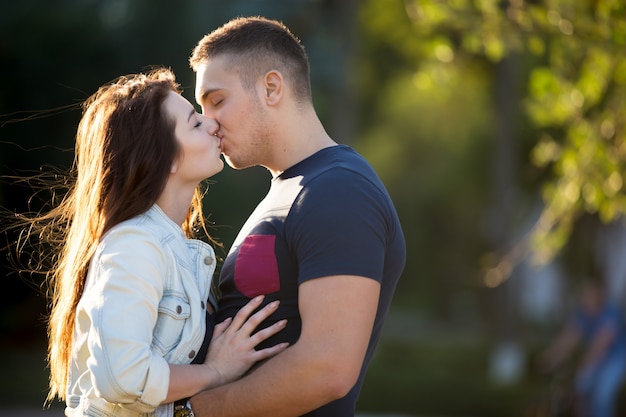 Jovem casal se beijando em um dia ensolarado