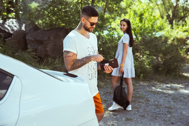 Jovem casal se preparando para as férias em um dia ensolarado de verão.