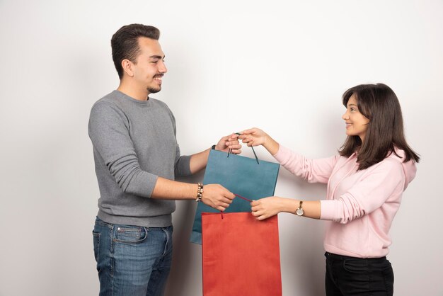 Jovem casal segurando sacolas de compras juntos.