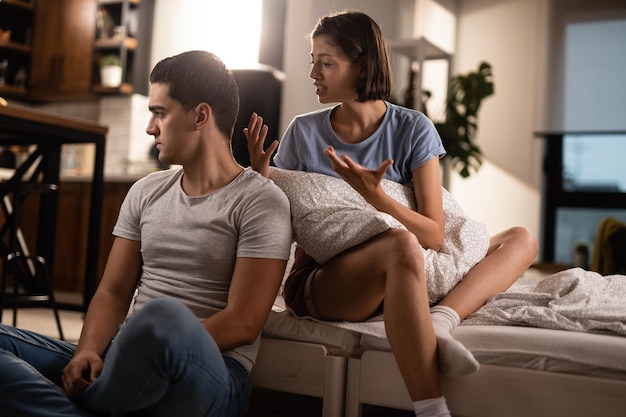 Foto grátis jovem casal tendo problemas em seu relacionamento e discutindo no quarto o homem está ignorando sua namorada