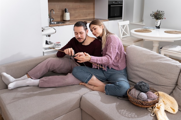 Foto grátis jovem casal tricotando juntos