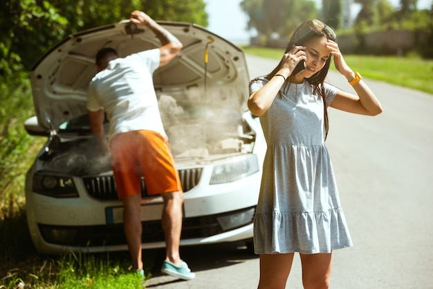 Jovem casal viajando no carro em um dia ensolarado