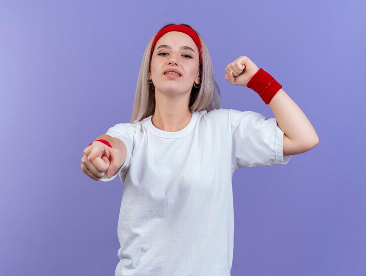 Foto grátis jovem caucasiana desportiva confiante com aparelho e faixa na cabeça