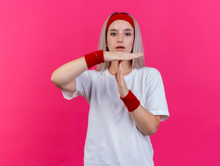 Foto grátis jovem caucasiana desportiva confiante com aparelho e faixa na cabeça