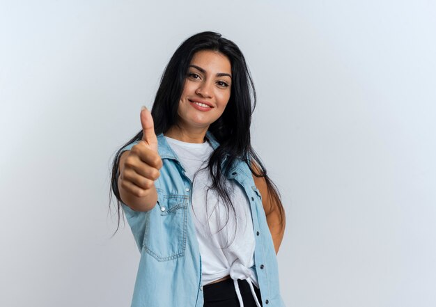 Jovem caucasiana sorridente com o polegar para cima olhando