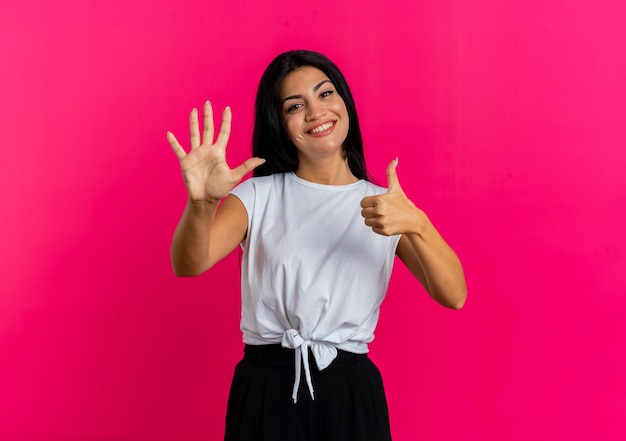 Foto grátis jovem caucasiana sorridente gesticula seis com os dedos