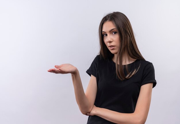 jovem caucasiana vestindo camiseta preta levantando a mão na parede branca isolada
