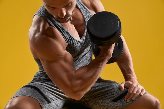 Foto grátis jovem cavalheiro musculoso bombando bíceps