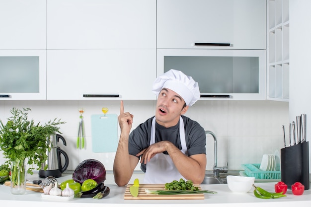 Jovem chef de uniforme na cozinha de frente