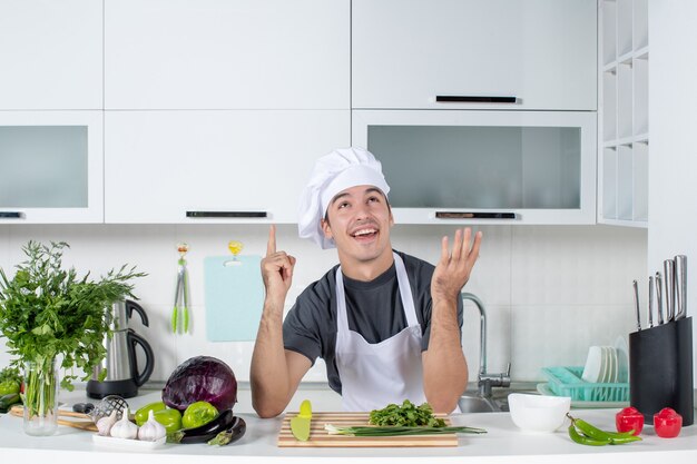 Jovem chef de uniforme olhando para cima