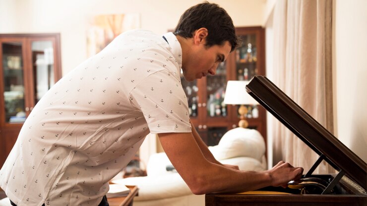 Foto grátis jovem colocando o disco de vinil no player em casa