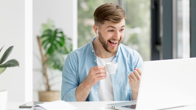 Jovem com airpods trabalhando no laptop