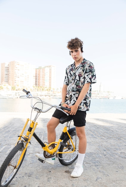 Jovem com bicicleta ouvindo música no fone de ouvido