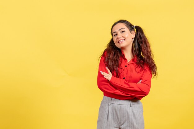 Jovem com blusa vermelha sorrindo em amarelo