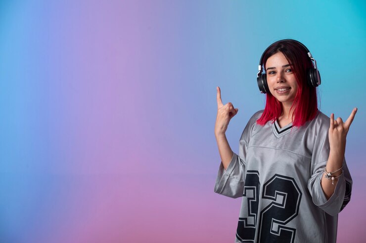 Foto grátis jovem com cabelos rosa parece positiva e usando fones de ouvido.