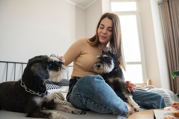 Jovem com cachorros na cama