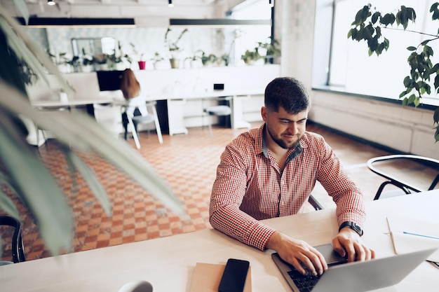 Jovem com camisa casual trabalhando no computador no escritório