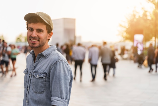 Foto grátis jovem com camisa, sorrindo em uma rua