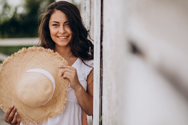 Jovem com chapéu e vestido de férias