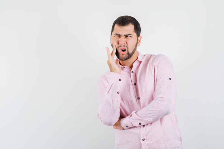 Foto grátis jovem com dor de dente usando uma camisa rosa e parecendo ansioso