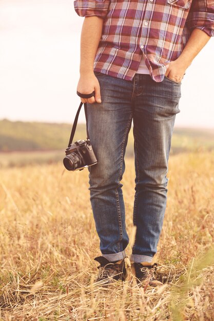 Jovem com hipster de câmera fotográfica retrô ao ar livre