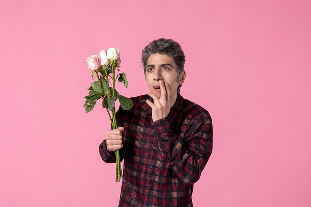 Jovem com lindas rosas cor de rosa na parede cor de rosa